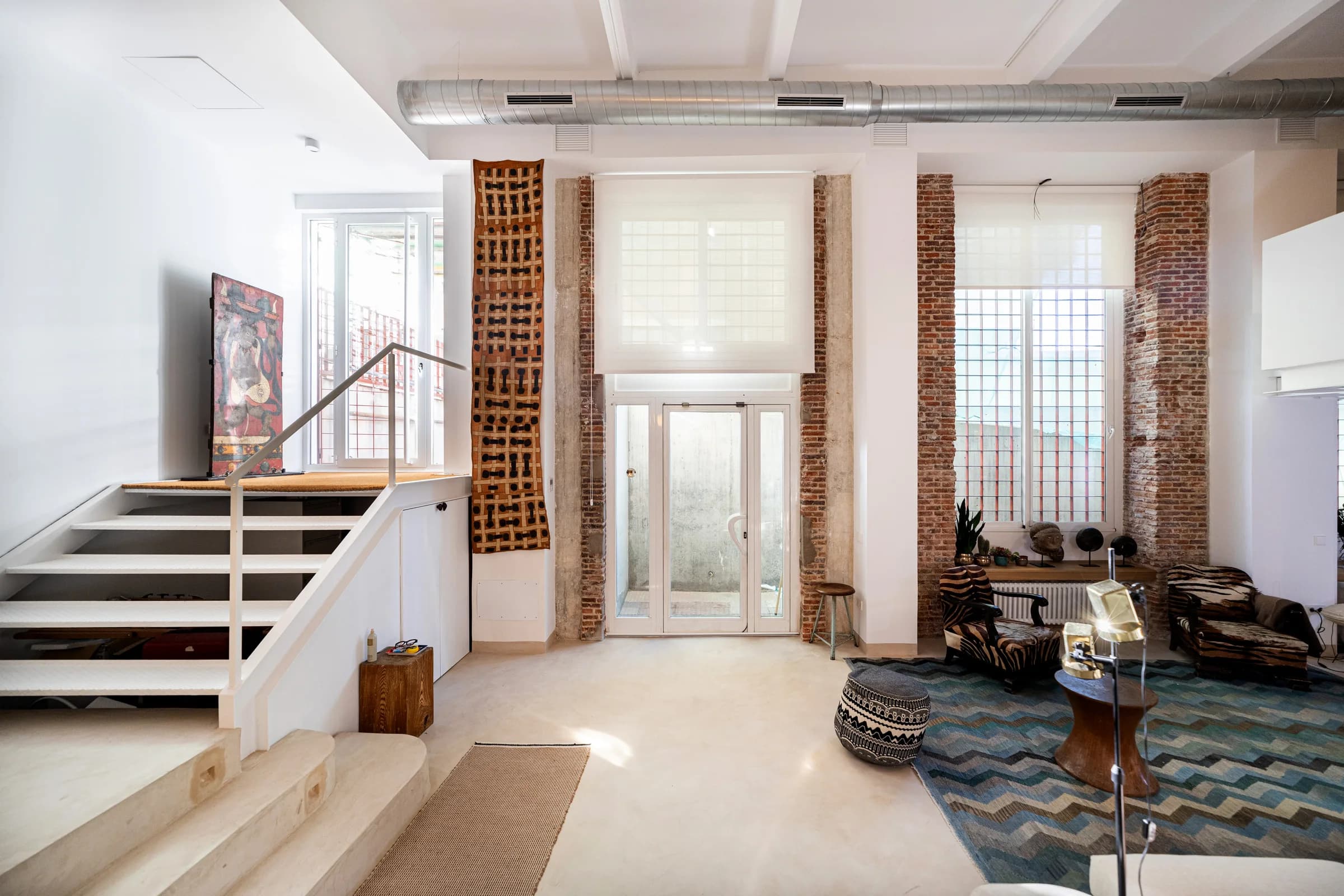 Tall windows framed by exposed brick